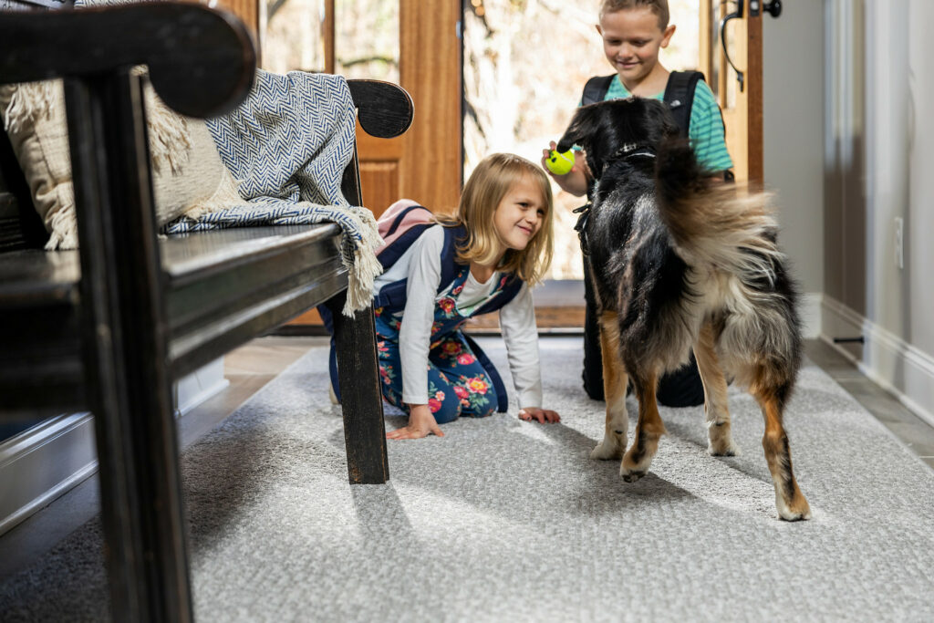Kids playing with dog on carpet floor | Chillicothe Carpet
